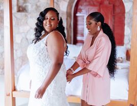 Bride getting ready with assistance from her maid of honor.
