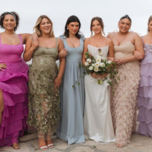 Group of wedding guests in colorful wedding guest dresses.
