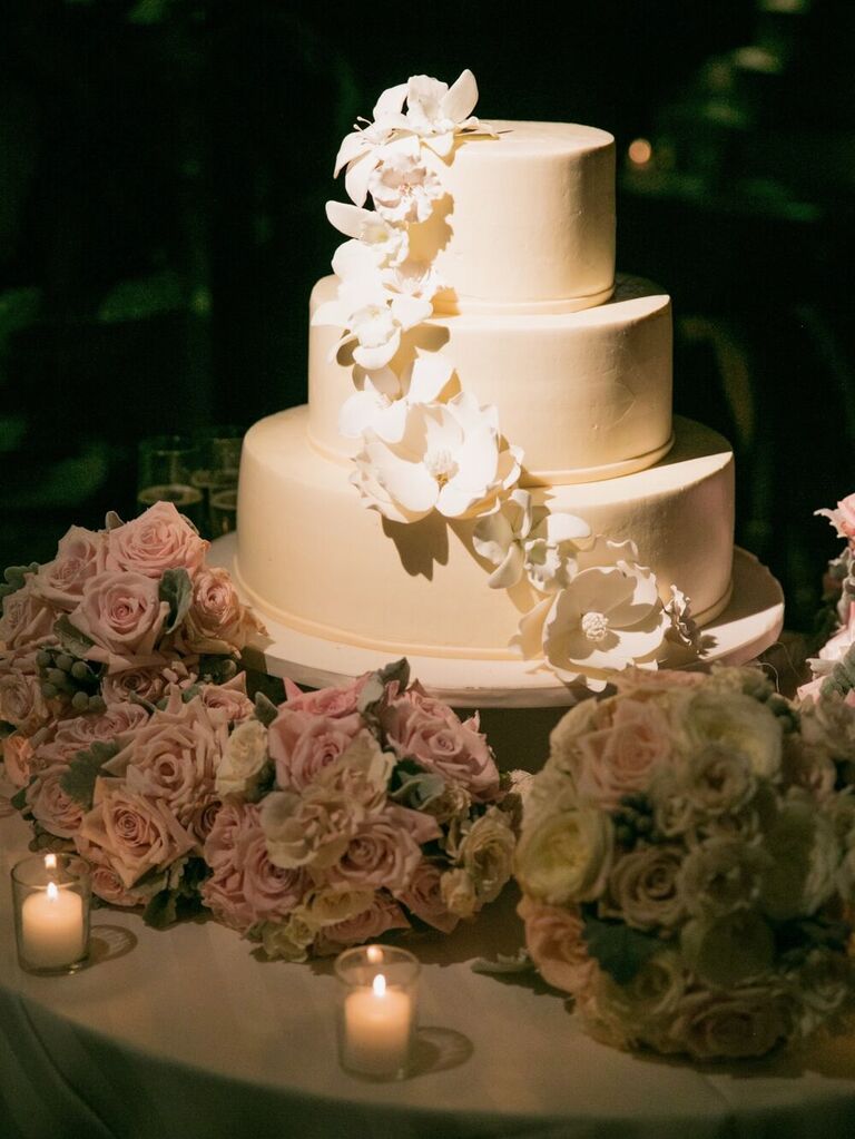 A three-tiered wedding cake with a waterfall of white sugar flowers