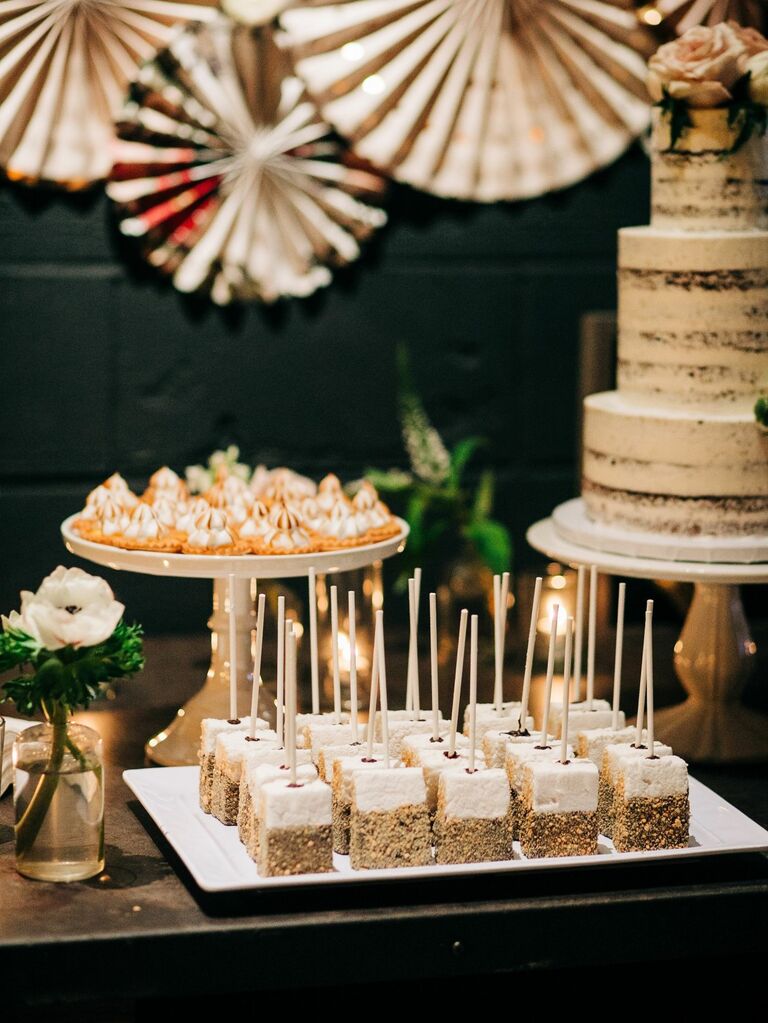 Dessert table featuring chocolate-dipped marshmallows on a stick. 