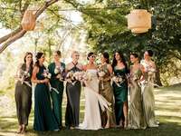 Bride with bridesmaids smiling while linking arms