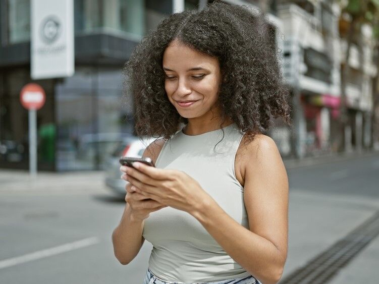 Woman smiling while looking at her phone