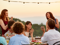 30th birthday trip ideas - Friends clapping while enjoying dinner party