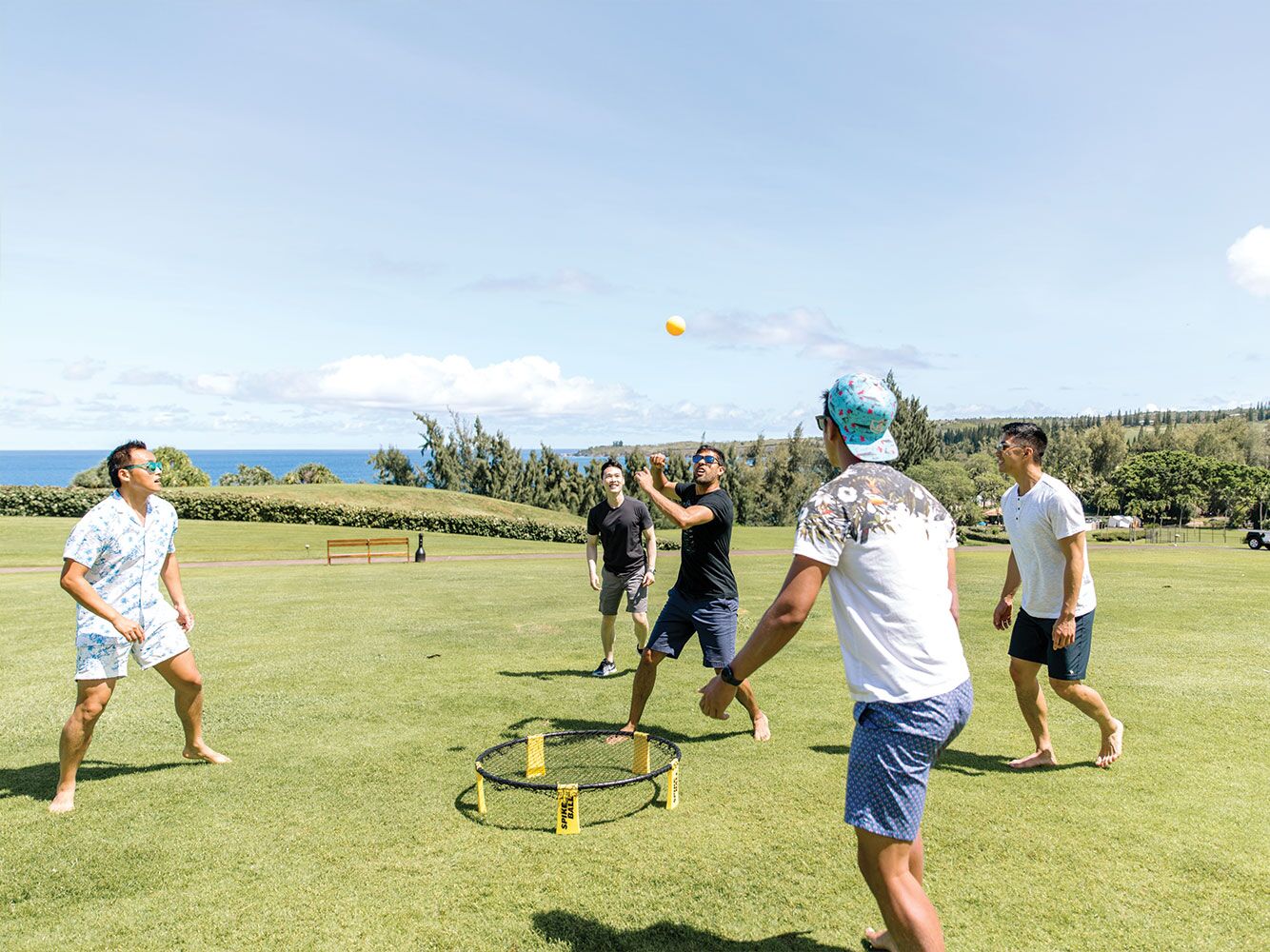 Group of men playing spikeball outside at bachelor party