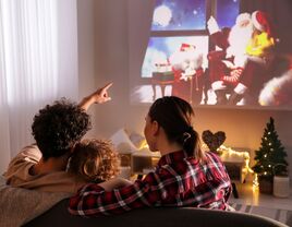 Happy couple with their child watching a holiday film