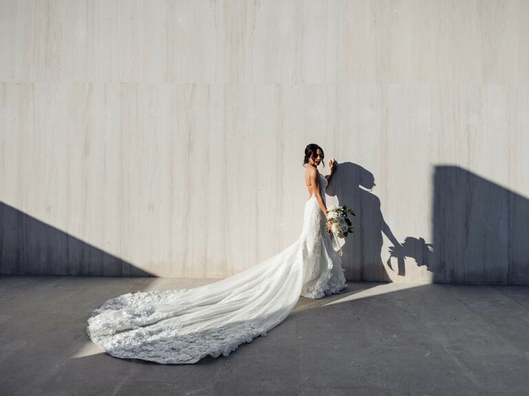 Bride wears an elegant wedding dress with a long train. 