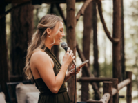 Woman giving speech at wedding in forest