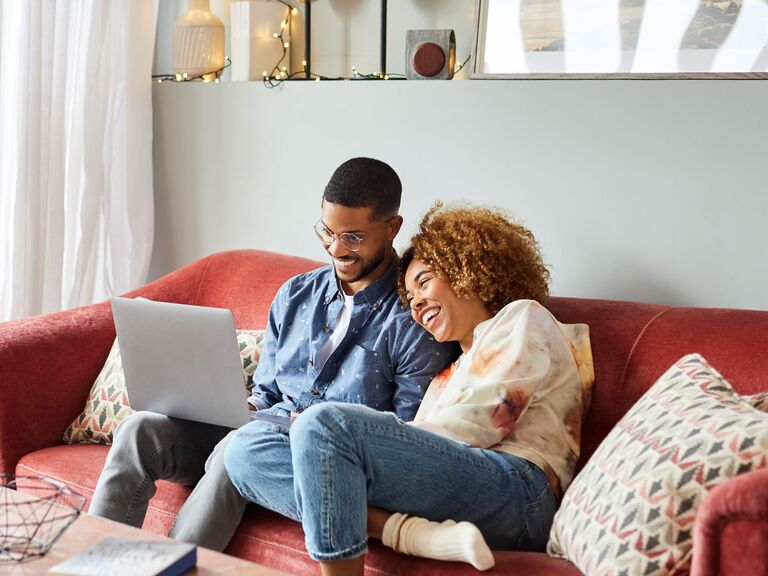 Couple creating bridal shower registry on laptop at home